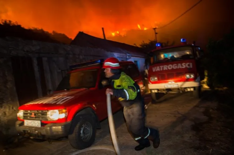 Požar na Pelje&scaron;cu jo&scaron; je uvijek aktivan, no ki&scaron;a koja je noćas nenadano pala pomogla je vatrogascima da ga stave pod kontrolu. Iscrpljeni vatrogasci borili su se doslovce za svaku kuću.  Prizori u galeriji zabilježeni su kod zaseoka Dančanje, na cesti prema Brijesti.