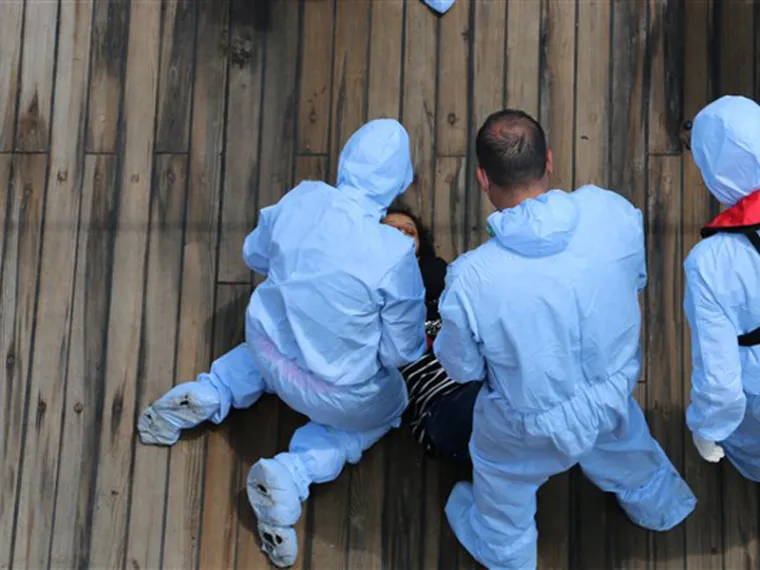 Policijski službenici pružaju pomoć iscrpljenoj ženi.