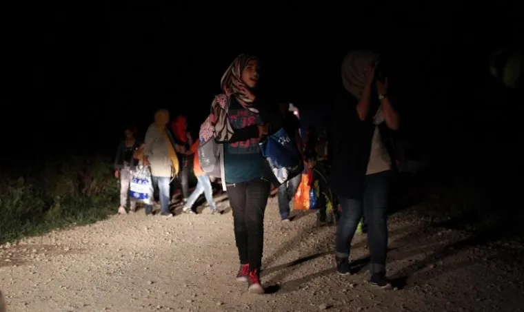 Izbjeglice cijeli dan ilegalno prelaze granicu RH kod Tovarnika. Iako je pao mrak ljudi i dalje po mraku kroz polje ulaze u Hrvatsku. Hrvatska policija čeka ih u polju, te policijskim kombijima prevozi u policijsku postaju Tovarnik.