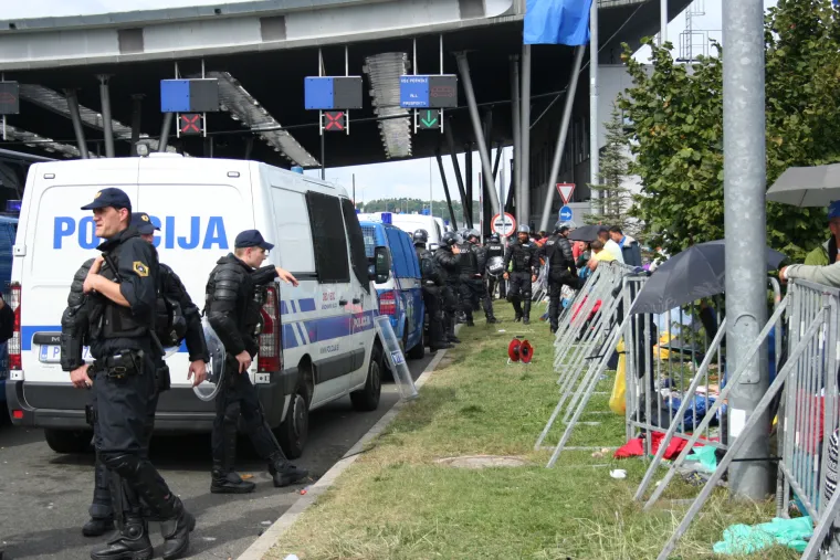 Jake snage slovenske policije iza ograde ne propu&scaron;taju izbjeglice dalje.