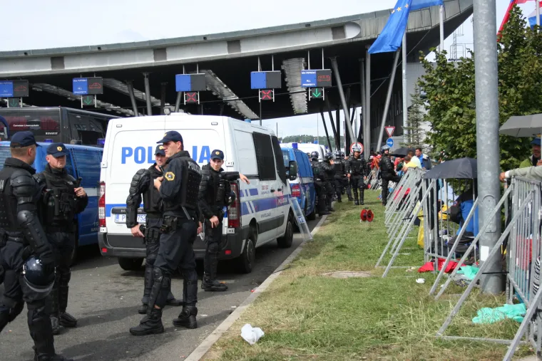 Jake snage slovenske policije iza ograde ne propu&scaron;taju izbjeglice dalje.