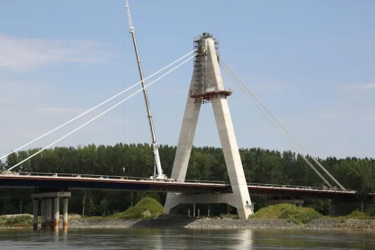 Najduži mostu Hrvatskoj koji je jo&scaron; u fazi izgradnje, smjestio se kod Petrijevaca a povezivat će dvije obale Drave, kao dio cestovnog koridora 5C Budimpe&scaron;ta-Osijek-Ploče. Ovih dana poprimio je svoj konačni izgled, pi&scaron;e Glas Slavonije.