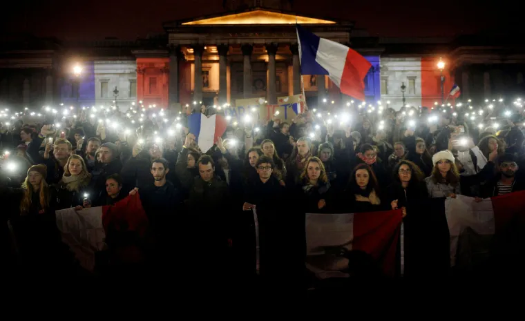 Svijet suosjeća s Parizom: simboli gradova u bojama  francuske zastave, cvijeće i svijeće za žrtve