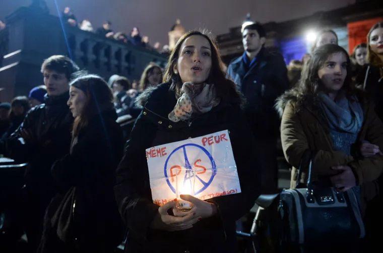 Svijet suosjeća s Parizom: simboli gradova u bojama  francuske zastave, cvijeće i svijeće za žrtve