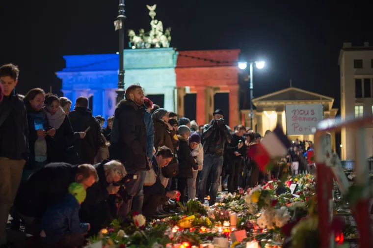 Svijet suosjeća s Parizom: simboli gradova u bojama  francuske zastave, cvijeće i svijeće za žrtve