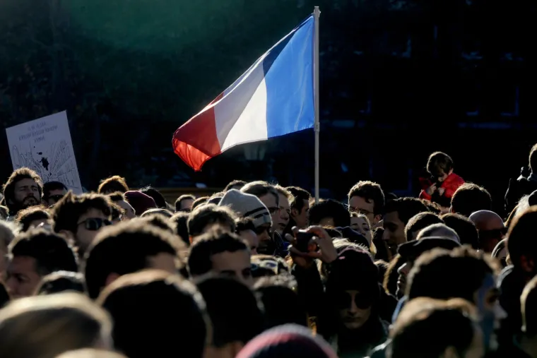 Svijet suosjeća s Parizom: simboli gradova u bojama  francuske zastave, cvijeće i svijeće za žrtve