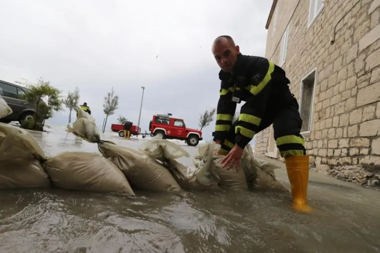 Olujno jugo poharalo ka&scaron;telanski zaljev. Vatrogasci grade zečji nasip.