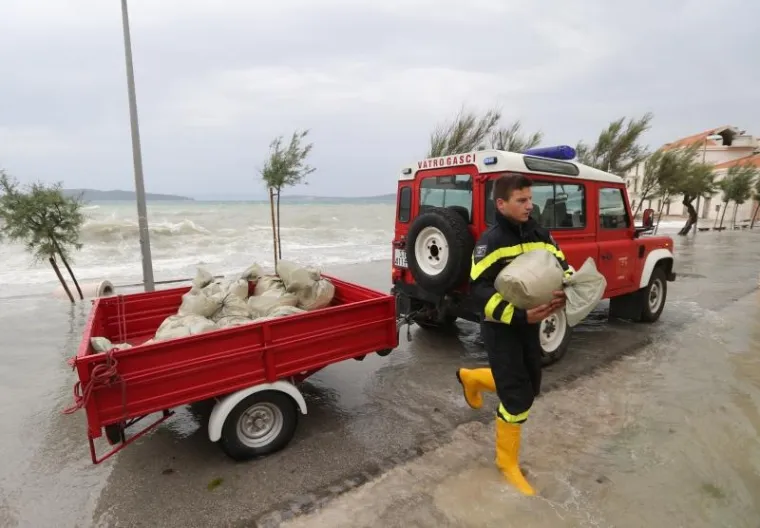 Olujno jugo poharalo ka&scaron;telanski zaljev. Vatrogasci grade zečji nasip.