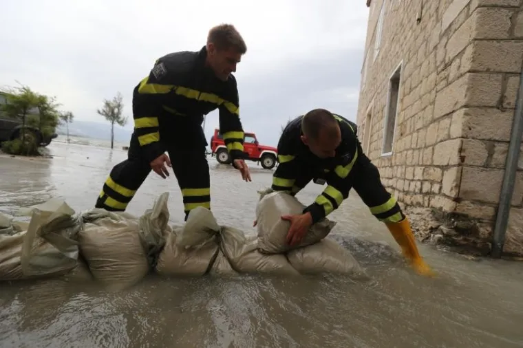 Olujno jugo poharalo ka&scaron;telanski zaljev. Vatrogasci grade zečji nasip.