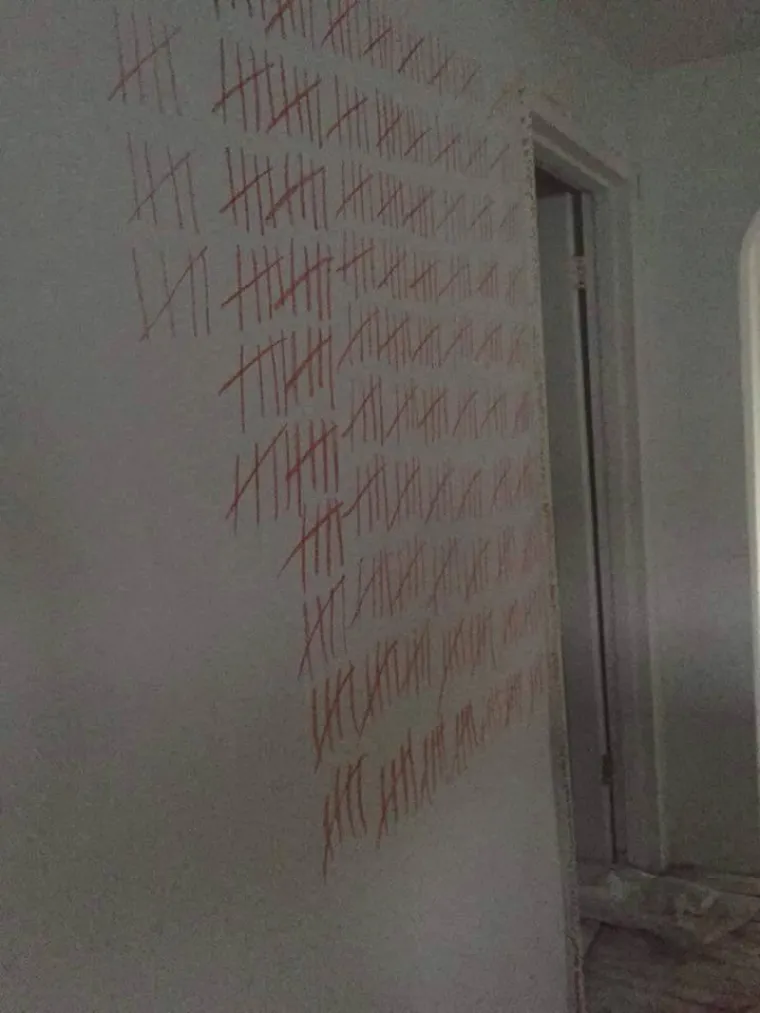 Zidovi po cijelom stanu bili su po&scaron;arani crvenom pastelom, kao da netko ne&scaron;to broji ili odbrojava.