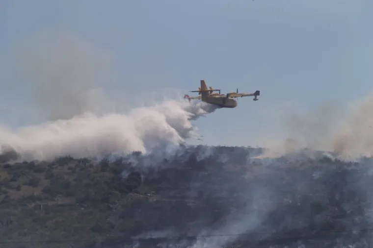 Požar koji je izbio pored igrališta u Trogiru počeo se, nošen vjetrom, vrlo brzo širiti prema deponiju. Na terenu je 60-ak vatrogasaca i dva kanadera, a gore trava i borova šuma.