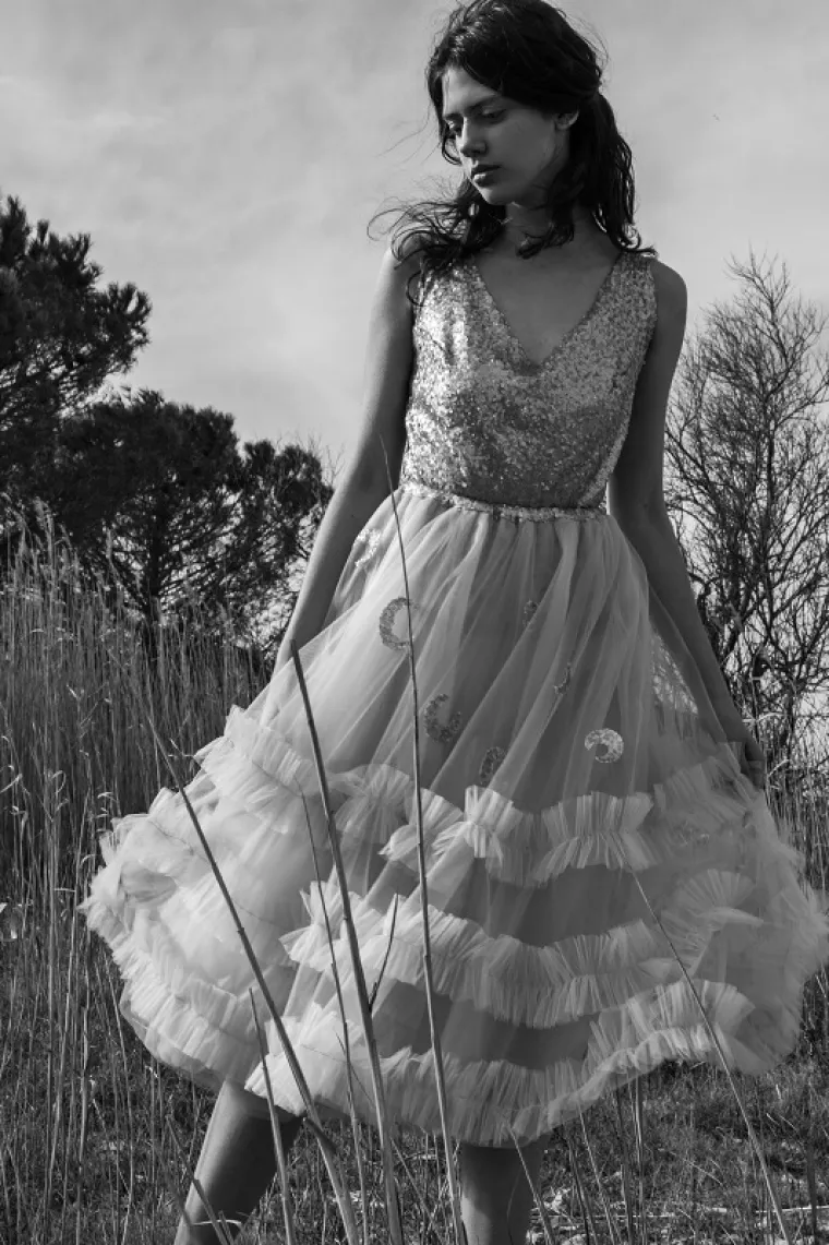 Svaki odjevni element razrađen je do najsitnijih detalja te svaki komad priča priču za sebe. Ri&scaron;lje čipka je najra&scaron;ireniji ručni rad a dolazi sa područja Slavonije.  Oslikani dijelovi na haljini daju poseban efekt kao i nijansirani i bojani cvijetići čipke na bluzama.