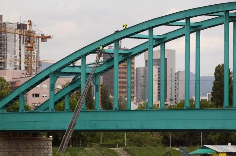 Radnici uklanjaju nedostatke i čiste željeznički most od grafita.