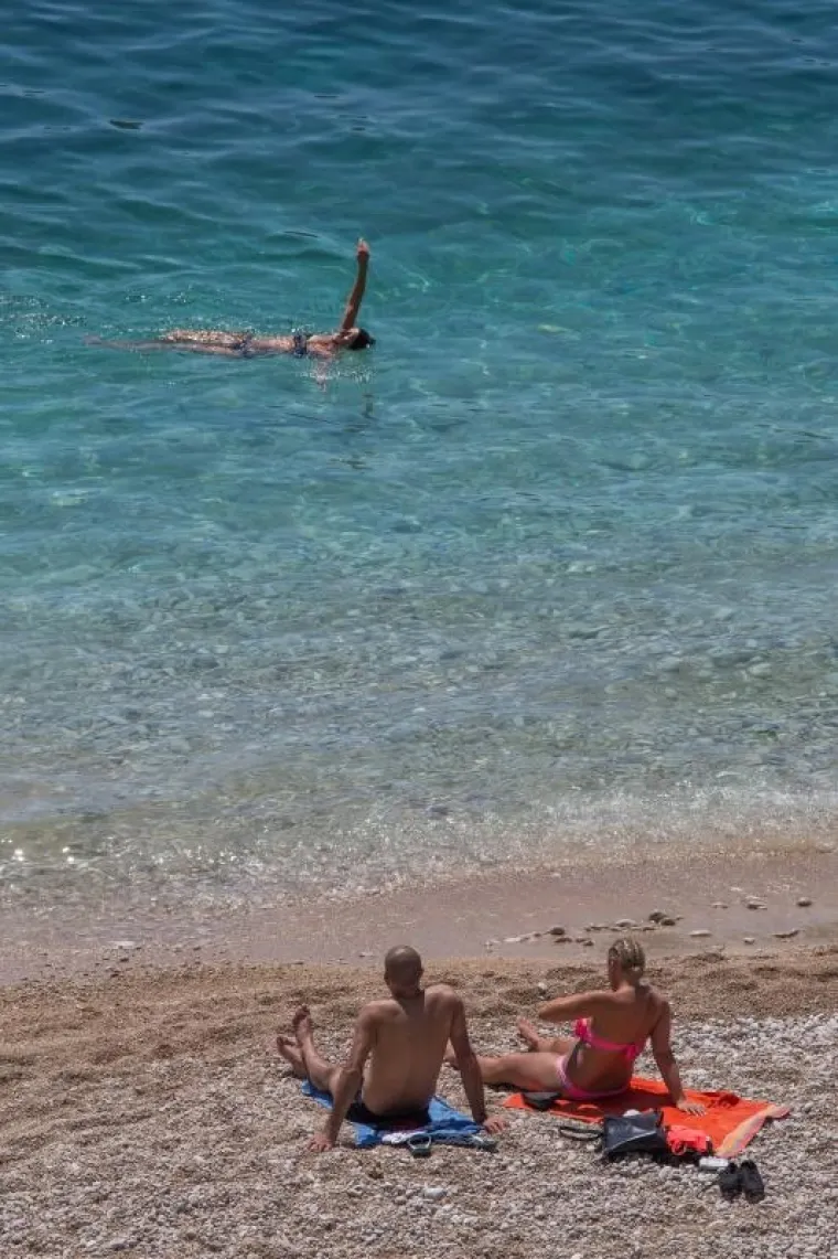 Turisti uživaju u kupanju na dubrovačkoj plaži Banje.