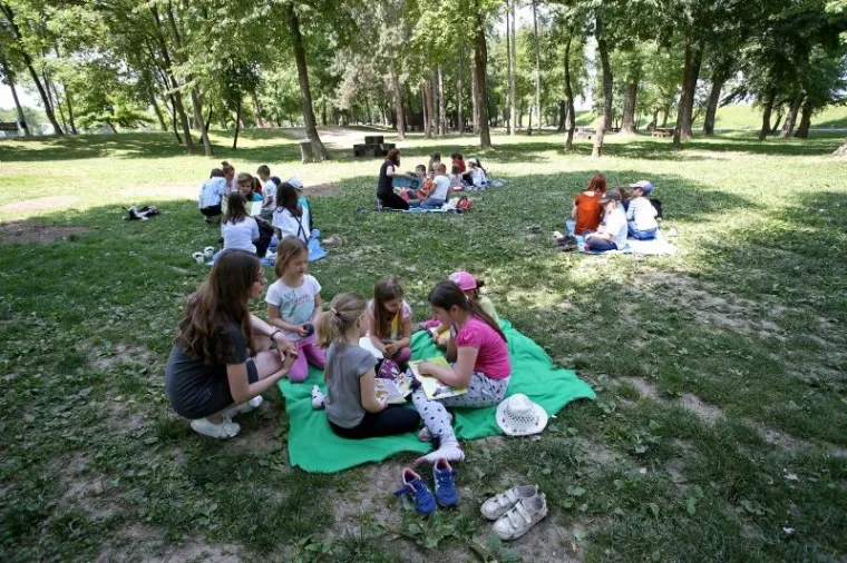 Djeca na dekama uživala u čitanju knjiga uz jezero Bundek