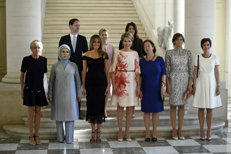 Na fotografiji su u prvome redu s lijeva na desno supruga novog francuskog prdsjednika Brigitte Macron, supruga turskog predsjednika Emina Gulbaran Erdogan, američka prva dama Melanija Trump, belgijska kraljica Matilda, partnerica glavnog tajnika NATO-a Ingrid Schulerud, supruga bugarskog predsjednika Desislava Radeva i partnerica belgijskog premijera Amelie Derbaudrenghien.