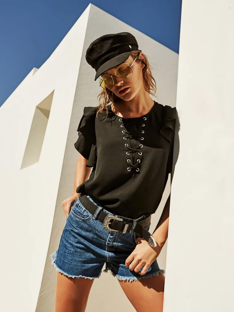 Crni top, kratke traper hlače, crni remen, crna kapa i avijatičarske naočale