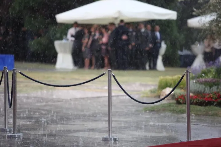 STISNULI SE POD &Scaron;ATORE: Pogledajte kako je pljusak rastjerao uzvanike na prijemu kod predsjednice povodom Dana državnosti