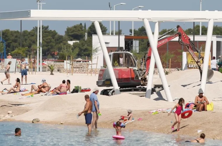 TURIZAM NA HRVATSKI NAČIN: Plaža nije dovr&scaron;ena u roku pa bageri kopaju dok se turisti kupaju