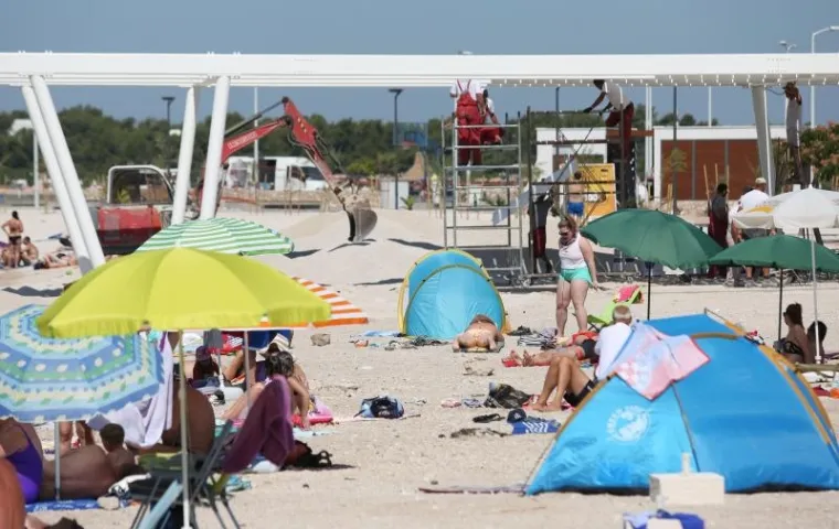 TURIZAM NA HRVATSKI NAČIN: Plaža nije dovr&scaron;ena u roku pa bageri kopaju dok se turisti kupaju