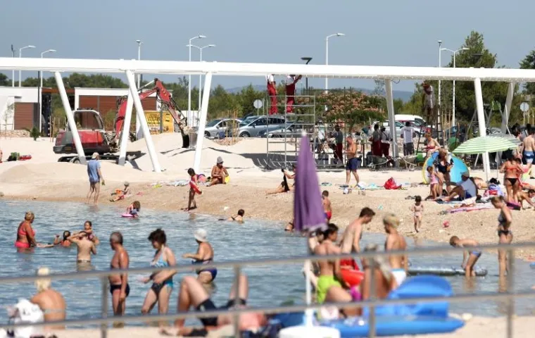 TURIZAM NA HRVATSKI NAČIN: Plaža nije dovr&scaron;ena u roku pa bageri kopaju dok se turisti kupaju