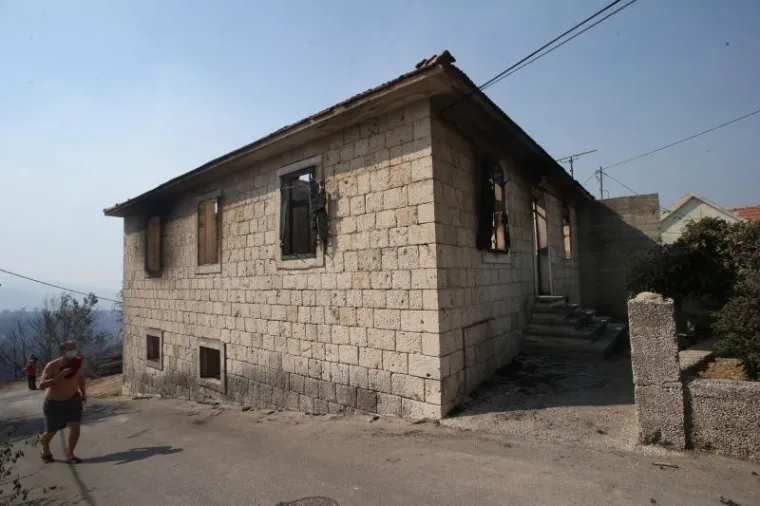 17.07.2017., Kucine, Mravince - Sokirani stanovnici dolaskom novog dana ugledali katastrofalno okruzenje oko njihovih kuca. Susjedi pored potpuno izgorene kuce u Mravincima u kojoj je zivjela majka sa sinom. Photo: Ivo Cagalj/PIXSELL