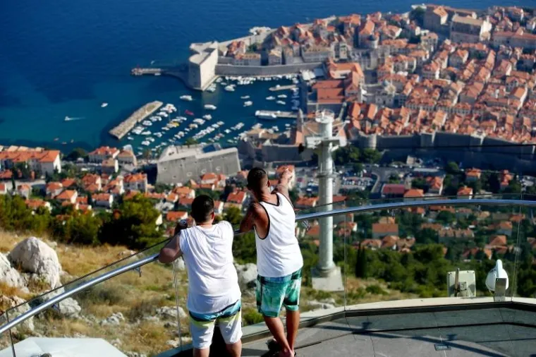 Turisti uživaju u pogledu na Dubrovnik s vidikovca na Srđu, do kojeg vozi žičara. Iako pogled oduzima dah, na sve se može staviti cijena pa tako i na pogled, za koji treba izdvojiti 140 kn po osobi.