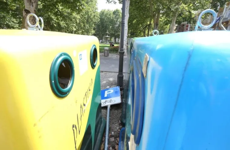 Pored spremnika za otpad nalazi se odbačeni znak parkinga za bicikle