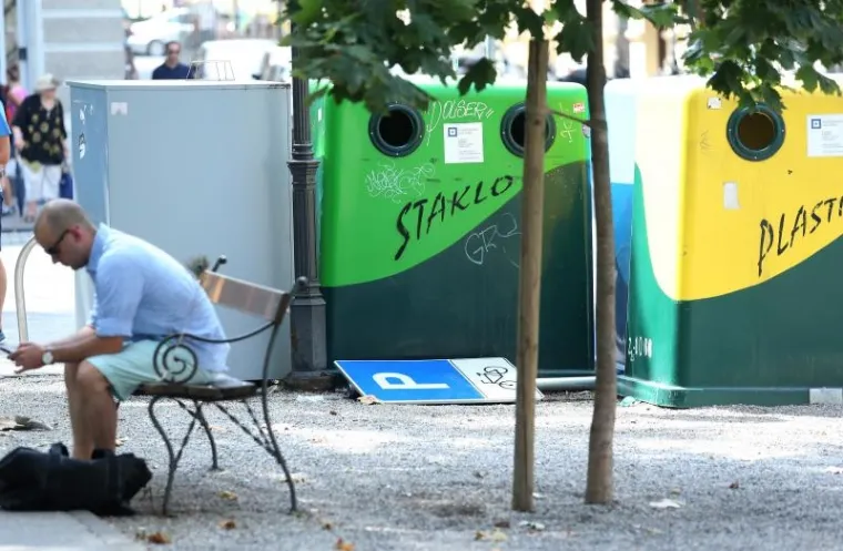 Pored spremnika za otpad nalazi se odbačeni znak parkinga za bicikle