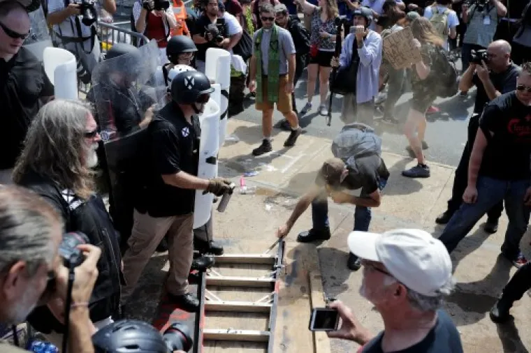 CHARLOTTESVILLE, VA - AUGUST 12: White nationalists, neo-Nazis and members of the "alt-right" clash with counter-protesters as they attempt to guard the entrance to Lee Park during the "Unite the Right" rally August 12, 2017 in Charlottesville, Virginia. After clashes with anti-fascist protesters and police the rally was declared an unlawful gathering and people were forced out of Lee Park, where a statue of Confederate General Robert E. Lee is slated to be removed.   Chip Somodevilla/Getty Images/AFP