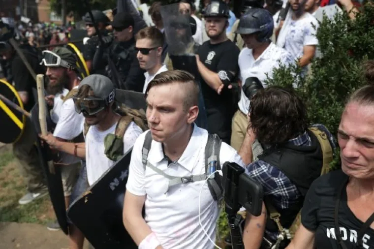 CHARLOTTESVILLE, VA - AUGUST 12: White nationalists, neo-Nazis and members of the "alt-right" exchange insluts with counter-protesters as they attempt to guard the entrance to Lee Park during the "Unite the Right" rally August 12, 2017 in Charlottesville, Virginia. After clashes with anti-fascist protesters and police the rally was declared an unlawful gathering and people were forced out of Lee Park, where a statue of Confederate General Robert E. Lee is slated to be removed.   Chip Somodevilla/Getty Images/AFP