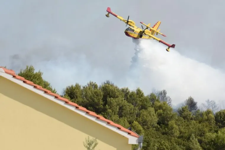 Oko 16 sati buknuo je veliki požar u gradskom predjelu Diklo. Gorjela je borova &scaron;uma u neposrednoj blizini obiteljskih kuća i vikendica. Nekoliko kanadera i air tractora pomažu zemaljskim snagama u ga&scaron;enju. 
Photo: Dino Stanin/PIXSELL
