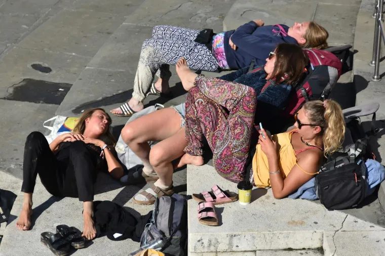 Nakon ki&scaron;nog osvježenja slijedi odmor: turistkinje uživaju na toplim stepenicama Portarate u Puli