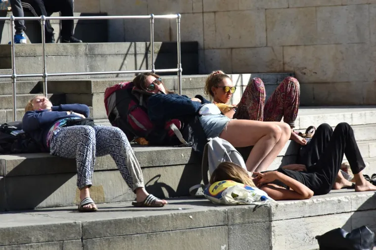 Nakon ki&scaron;nog osvježenja slijedi odmor: turistkinje uživaju na toplim stepenicama Portarate u Puli