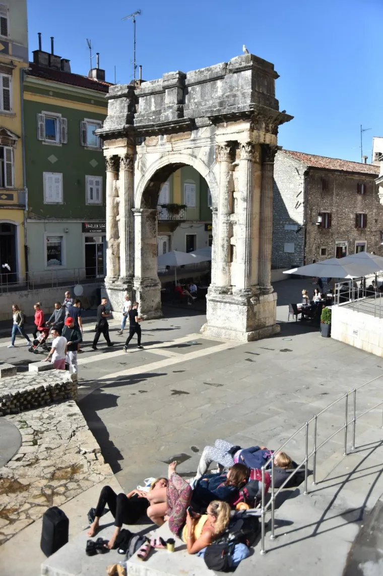 Nakon ki&scaron;nog osvježenja slijedi odmor: turistkinje uživaju na toplim stepenicama Portarate u Puli