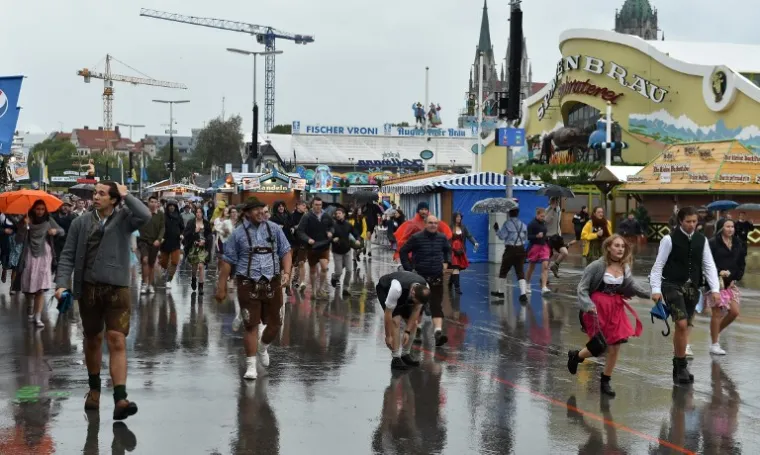 "Oktoberfest je nešto što morate zaslužiti", rekao je Ryan dok je u redu čekao na kiši sa skupinom prijatelja koji su zajedno s njime stigli iz Kanade.  Većina posjetitelja okupljenih u subotu bila je odjevena u tradicionalnu bavarsku odjeću, uključujući "dindrlice" i kožne hlače.