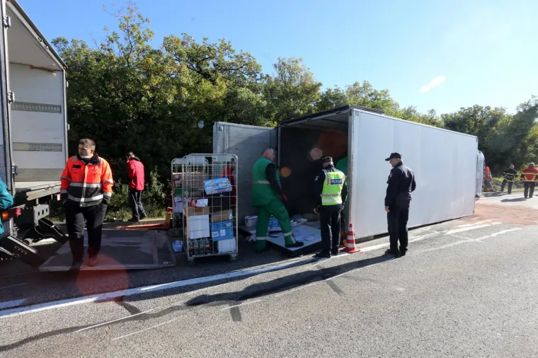 Prometna nesreća četiri vozila u kojoj su dvije osobe ozlijeđene dogodila se u jutarnjim satima na Jadranskoj magistrali iznad mjesta Jadranovo. Policija obavlja očevid, a djelatnici Konzuma prekrcavaju teret prevrnutog kamiona.