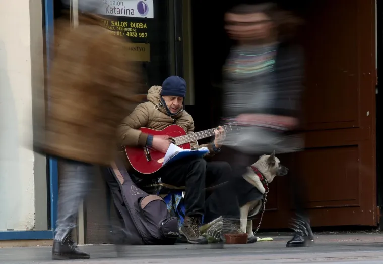 21.11.2017., Zagreb, Ilica - Ulični svirač u dru&scaron;tvu psa zabavlja prolaznike.