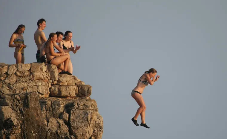 06.08.2017., Dubrovnik, Lokrum - Kupači skaču sa stijena u more na plaži Ploče na Lokrumu.
