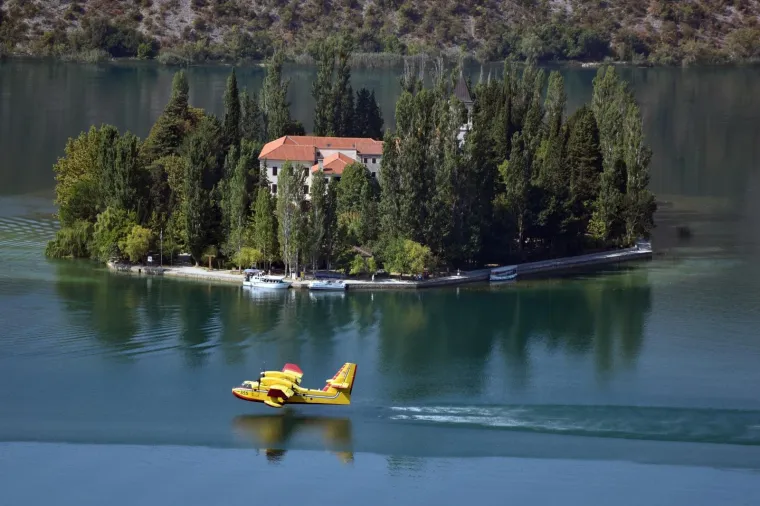 19.08.2017., Visovac - Piloti hrvatskih kanadera odu&scaron;evili turiste atraktivnim letovima i uzimanjem vode kod samostana Visovac u Visovačkom jezeru za potrebe ga&scaron;enja požara na Promini.