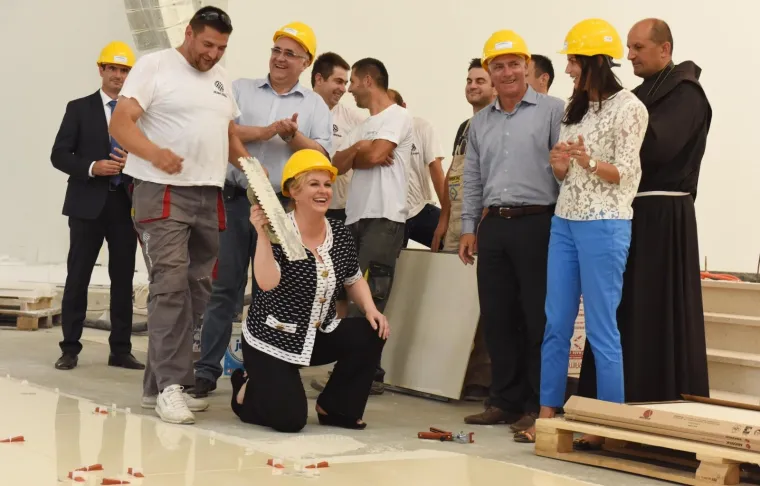 13.07.2015., Knin - Predsjednica Republike Hrvatske Kolinda Grabar-Kitarovic obisla je crkvu Gospe Velikog Hrvatskog Krsnog Zavjeta koja je u izgradnji te pokazala umijece lijepljenja plocica u podu. Photo: Hrvoje Jelavic/PIXSELL