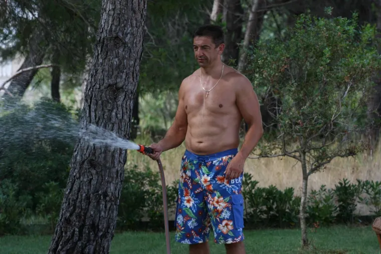 Darko Milinović na ljetovanju, zalijeva travu...