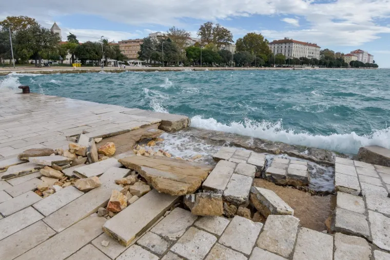 Inače prekrasna zadarska riva sinoć je razornim djelovanjem valova viskih i 4 metra te&scaron;ko o&scaron;tećena. Mul je gotovo u potpunosti potpuno uni&scaron;ten, a od prethodnih juga podlokana riva na mjestima je razrovana poput razbacanih kockica koje opet treba složiti na svoje mjesto. O&scaron;tećenja se vide i kod instalacije Morske orgulje a prve procjene govore da se radi o milijunskim &scaron;tetama.