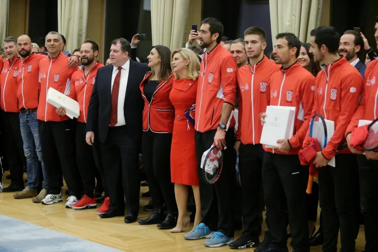 Predsjednica Kolinda Grabar-Kitarović odlikovala je pobjednike Davis Cupa. Za tu prigodu odjenula je vatreno crvenu usku haljinu do koljena koju su krasili zlatni detalji te kopče na ramenu.  Uz nju je  iskombinirala i cipele u boji kože.