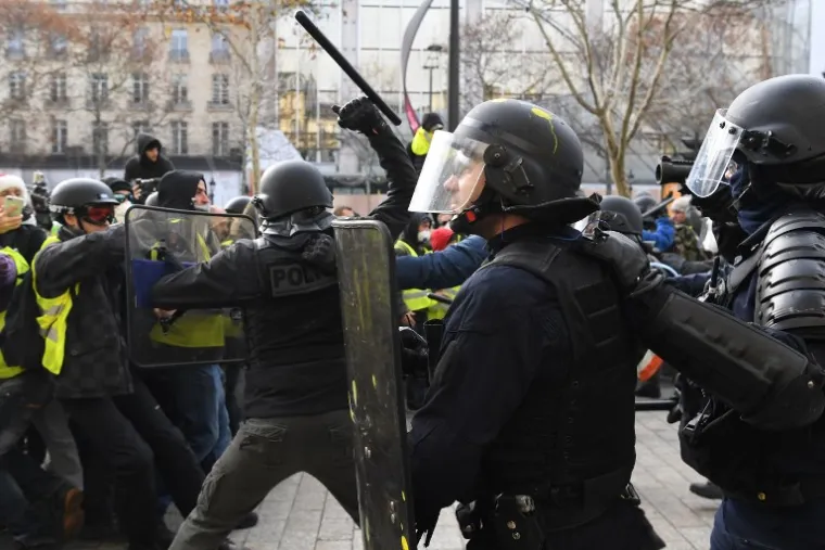 Riot police clash with "yellow vest" (gilet jaune) protestors on December 8, 2018 near the Arc de Triomphe in Paris during a protest against rising costs of living they blame on high taxes. - Paris was on high alert on December 8 with major security measures in place ahead of fresh "yellow vest" protests which authorities fear could turn violent for a second weekend in a row. (Photo by Alain JOCARD / AFP)