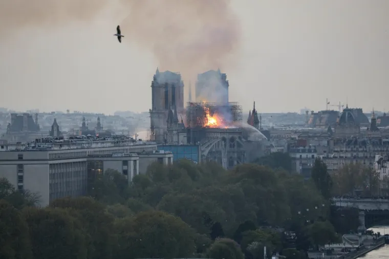 Flames and smoke are seen billowing from the roof at Notre-Dame Cathedral in Paris on April 15, 2019. - A fire broke out at the landmark Notre-Dame Cathedral in central Paris, potentially involving renovation works being carried out at the site, the fire service said.Images posted on social media showed flames and huge clouds of smoke billowing above the roof of the gothic cathedral, the most visited historic monument in Europe. (Photo by LUDOVIC MARIN / AFP)