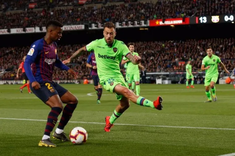 Portuguese defender Nelson Semedo (L) vies with Levante's Spanish defender Antonio Luna during the Spanish League football match between FC Barcelona and Levante UD at the Camp Nou stadium in Barcelona on April 27, 2019. (Photo by PAU BARRENA / AFP)