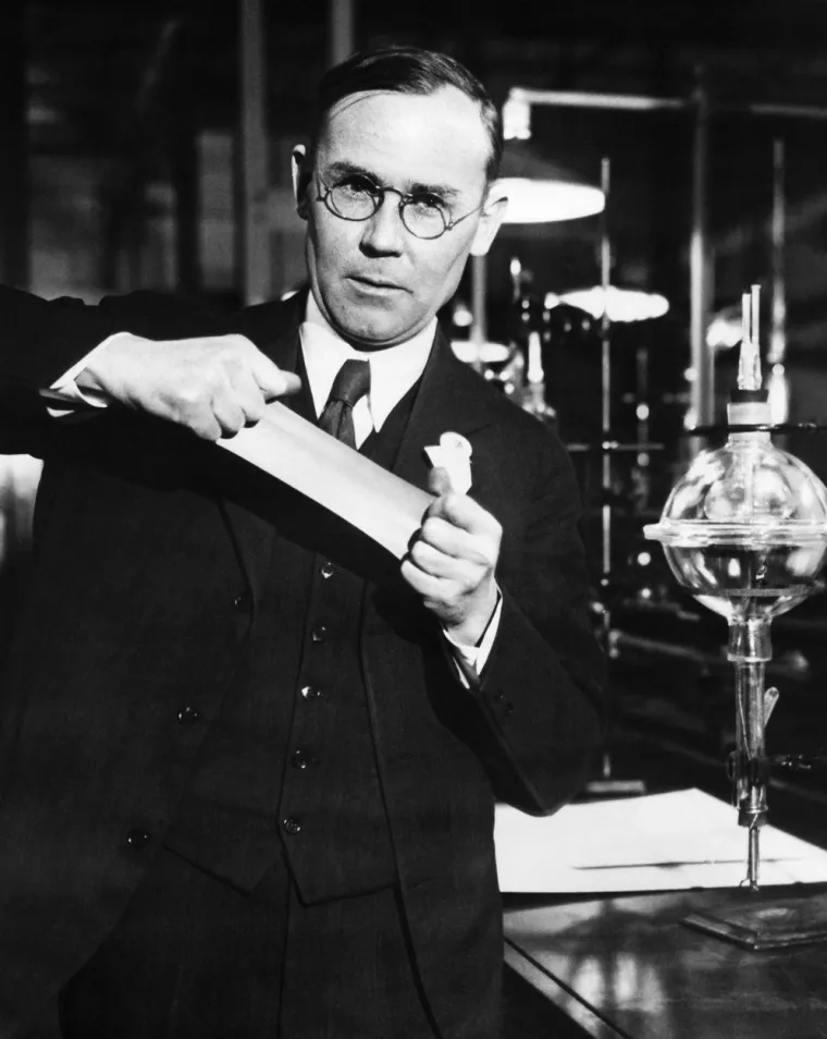 Za razvoj najlona najzaslužniji je kemičar  Wallace Hume Carothers (1896.-1937.). Nakon doktorata na Sveučilištu Illinois, 1927. zaposlio se  u DuPontu kako bi vodio odjel istraživanja organske kemije. Radio je na polimerima i nakon tri godine, 1930., njegov tim je napravio neopren. Ta sintetska guma, koju rasteže na fotografiji, bila je otpornija na toplinu i imala je veću vlačnu čvrstoću od bilo kojeg prirodnog materijala.  Kasnije te godine, njegov tim je napravio novo vlakno, poliamid, koje je nazvao najlon. Masovnu proizvodnju nije doživio. Carothers je bolovao od teškog oblika manične depresije  i 1937. je počinio samoubojstvo.