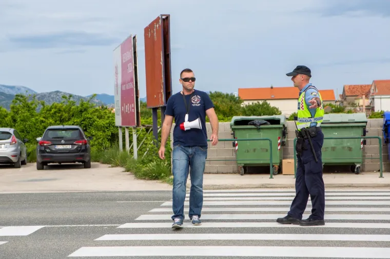 Jedan prosvjednik na prosvjedu u Opuzenu za bolje zdravstvo, predstavnik Građanske inicijative "Sinovi i kćeri Neretve" Ivan Matičević, prelazi preko pje&scaron;ačkog prijelaza. Mjesto prosvjeda osigurava pedesetak policajaca.
Matičević je priveden ne&scaron;to prije podneva zbog prijave o prijetnji jednom članu građanske inicijative.