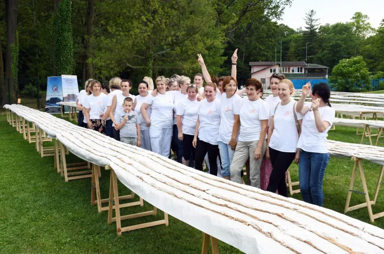 21.07.2019., Sisak - Grad Sisak upisao se u knjigu Guinnessovih rekorda, a sve zahvaljujući Autoprometu Sisak koji je inicirao pečenje najdulje štrudle na svijetu. U sklopu manifestacije City Games uz bazene Caprag bila je izložena najdulja štrudla na svijetu. Riječ je o tradicionalnoj štrudli od jabuka koja je bila duga više od 1,7 km, a koja je nakon mjerenja razdijeljena okupljenim građanima. Foto: Nikola Čutuk/PIXSELL